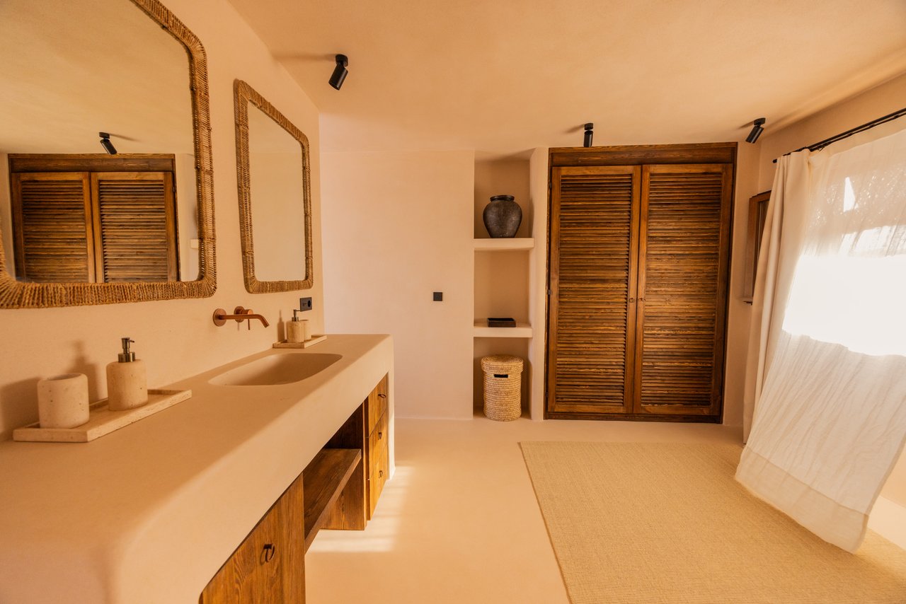 Baño de la habitación 03 con lavabo de obra y espejos de marco natural