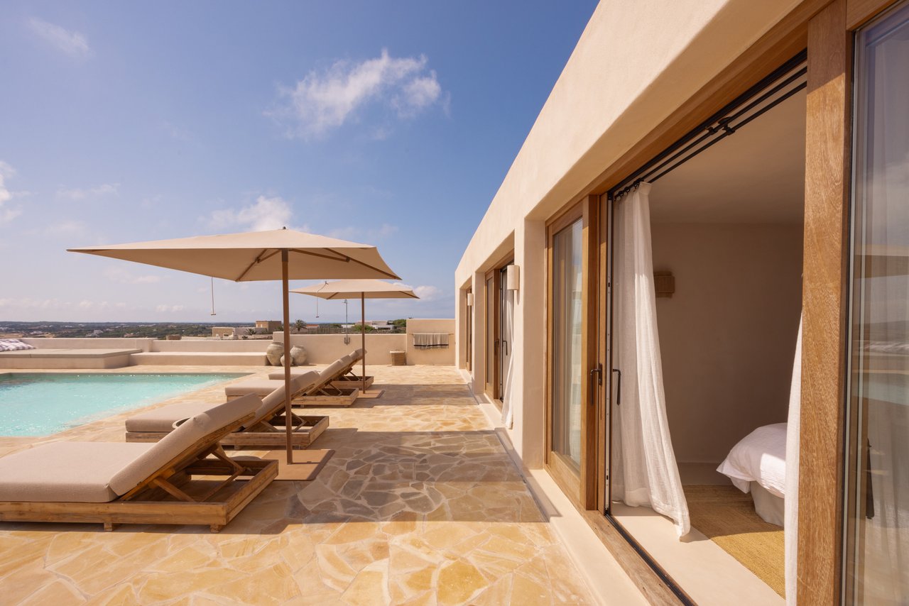 Terraza de tumbonas junto a las habitaciones, con las correderas abiertas